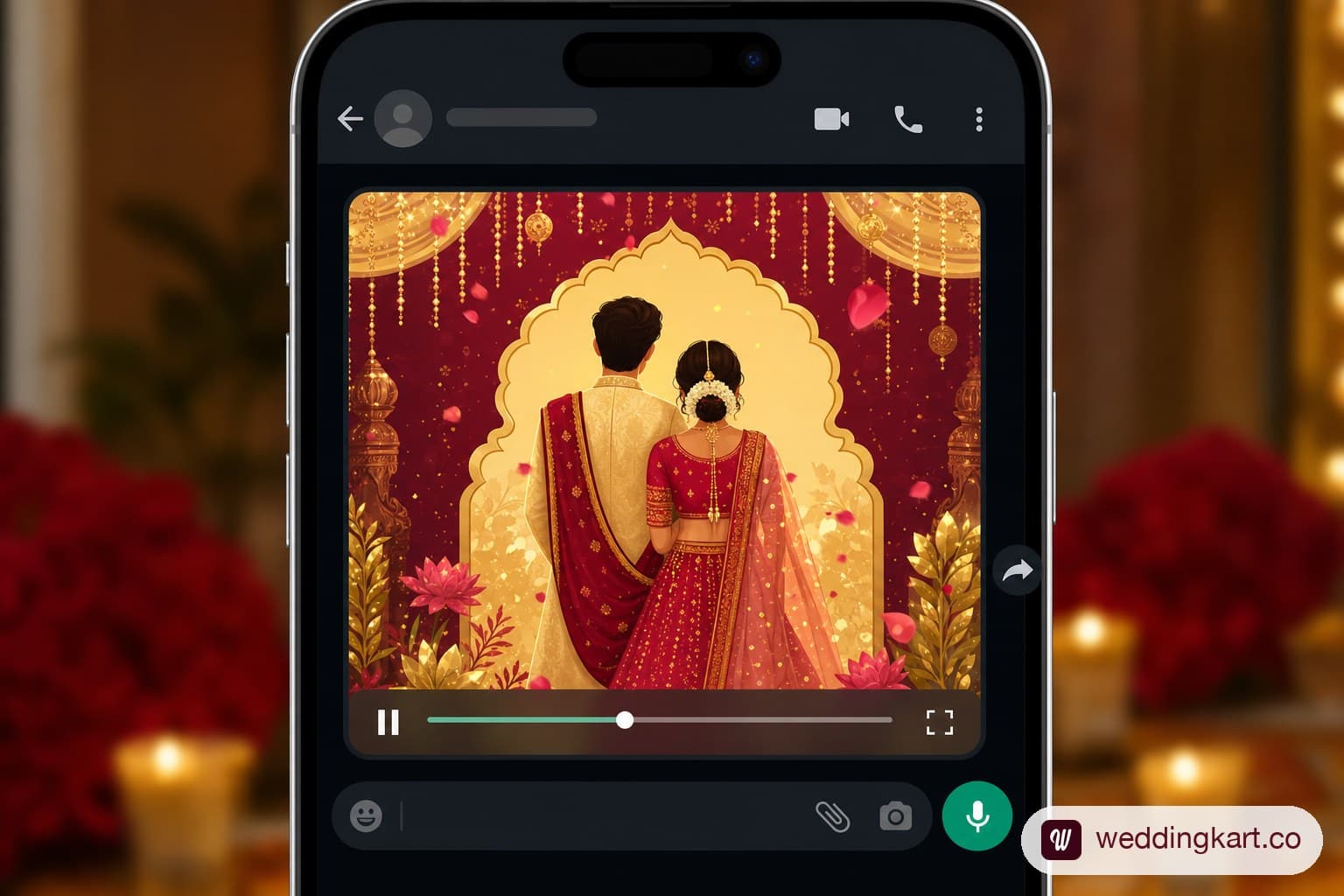 A phone playing a colourful animated wedding invitation video inside a WhatsApp chat window in a festive gold and red palette