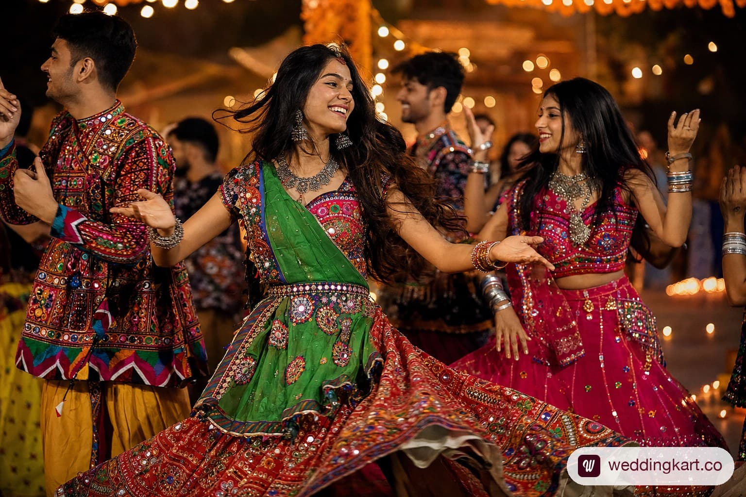 A group of friends dancing at a Gujarati Garba night in vibrant rented chaniya cholis with mirror-work embroidery in red, green and fuchsia