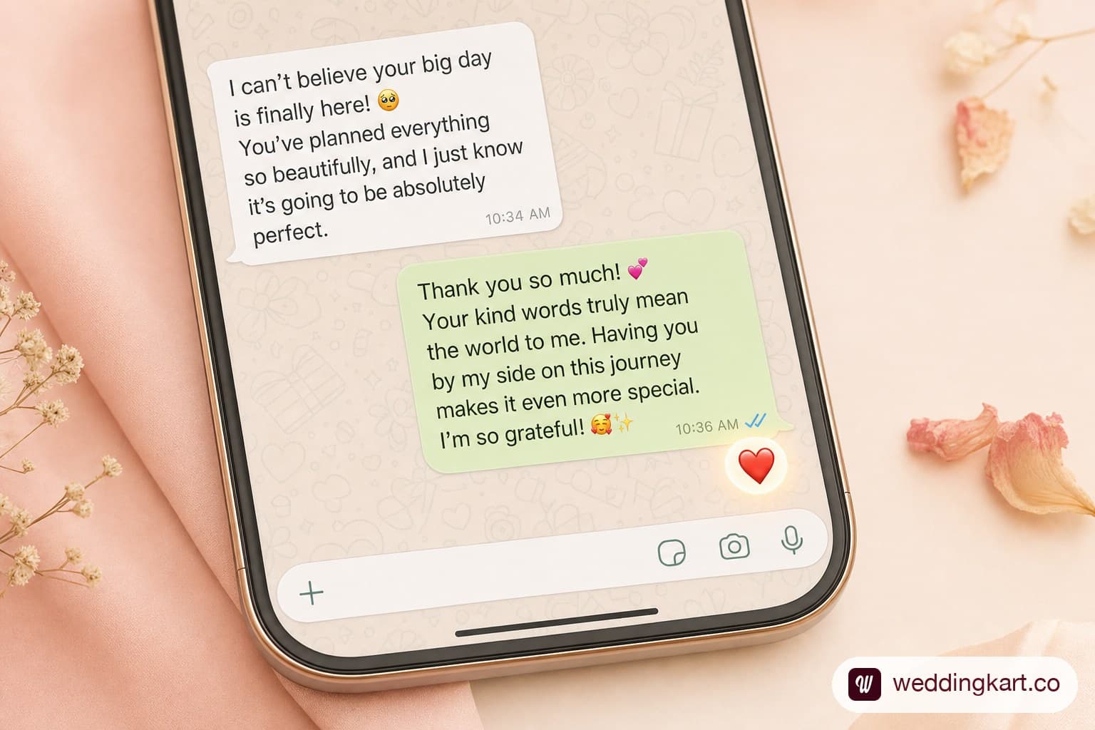 A WhatsApp chat bubble showing a warm wedding invitation reply message with a small heart reaction underneath